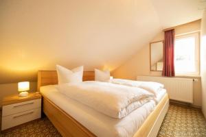 een slaapkamer met een bed met witte lakens en een raam bij Ferienhof Laibold-Evers in Hofbieber