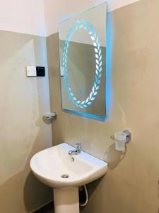 a bathroom with a sink and a mirror at Liyara Lodge Sigiriya in Sigiriya