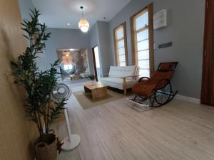 a living room with a couch and a chair at Idaman Homestay Ayer Tawar Tok Bali in Pasir Puteh