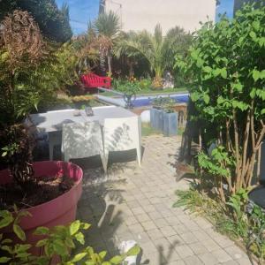 Un patio con una mesa blanca y algunas plantas. en Chambre hôtes nichée sous les toits, en Rennes