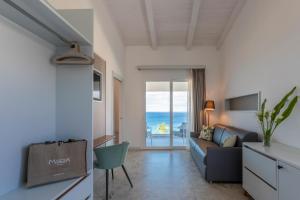 a living room with a couch and a view of the ocean at Midenza Seaside & Nature Retreat in Capo Vaticano