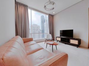 a living room with a couch and a large window at Soho Suites KLCC by GuestHouse in Kuala Lumpur