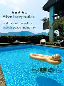 una piscina con un flotador en el agua en Residence Collina d'Oro, en Collina d'Oro