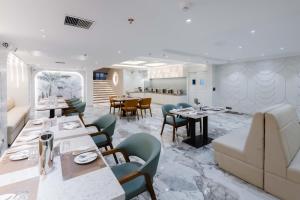 a restaurant with tables and chairs and a kitchen at Emerald Luxe A Boutique Hotel Chandigarh Mohali in Mohali