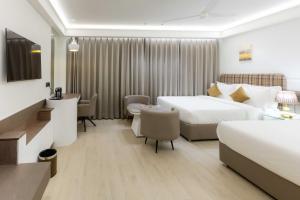 une chambre d'hôtel avec deux lits et un bureau dans l'établissement Emerald Luxe A Boutique Hotel Mohali Chandigarh, à Sohāna