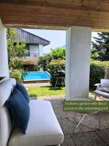 Una sala de estar con un sofá y una piscina. en Residence Collina d'Oro, en Collina d'Oro