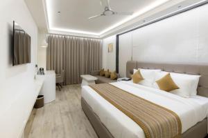 une chambre d'hôtel avec un grand lit et une salle de bain dans l'établissement Emerald Luxe A Boutique Hotel Mohali Chandigarh, à Sohāna