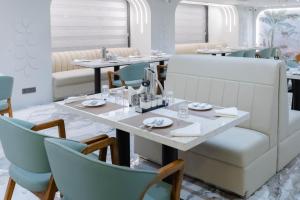 a dining room with a table and chairs at Emerald Luxe A Boutique Hotel in Sohāna +27 photos