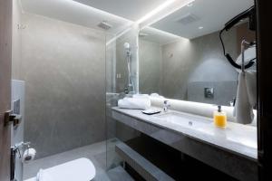 a bathroom with a sink and a toilet and a mirror at Emerald Luxe A Boutique Hotel in Sohāna