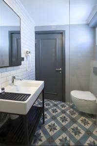 a bathroom with a sink and a toilet and a mirror at Smart City Suites Hotel Bodrum in Bodrum City