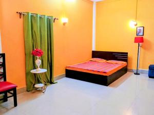 a bedroom with a bed and a vase of flowers at Hotel Baruah Tower in Tezpur