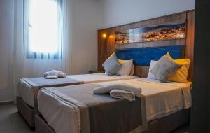 two beds in a hotel room with towels on them at Smart City Suites Hotel Bodrum in Bodrum City