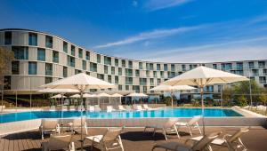 a hotel with a swimming pool with chairs and umbrellas at Maistra Select Family Hotel Amarin in Rovinj