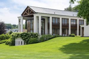 ErmatingenLILIENBERG的一栋前面有绿色草坪的大房子