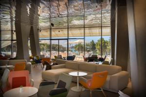 a lobby with a couch and tables and chairs at Maistra Select Family Hotel Amarin in Rovinj