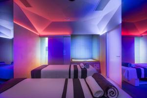 a room with two beds with colorful lights at Maistra Select Family Hotel Amarin in Rovinj