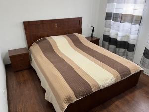 a bedroom with a bed with a striped comforter at Apartament w Ostródzie in Ostróda