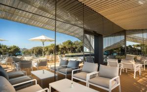 a patio with chairs and tables and an umbrella at Maistra Select Family Hotel Amarin in Rovinj