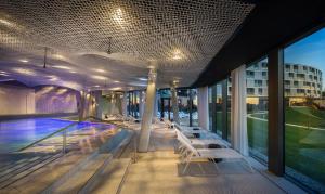 a building with a pool and chairs on the roof at Maistra Select Family Hotel Amarin in Rovinj