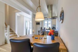 una sala da pranzo con tavolo e sedie in legno di Haus Kniepsand, Wohnung Treibsand a Wittdün Altre 10 foto