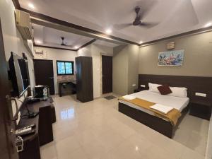 a bedroom with a bed and a television in it at Hotel Sejal in Calangute