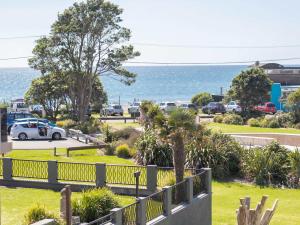 a view of the ocean from a parking lot at Aqua Vista On Arden - beachfront bach in Oakura in Oakura