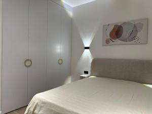 een witte slaapkamer met een bed en een lamp bij Khan Shatyr Luxe Apartaments - Breakfast included in Astana