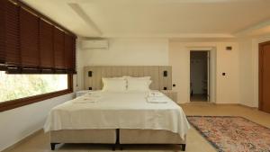 a bedroom with a large white bed with a window at BK Hotel in Fethiye +73 photos