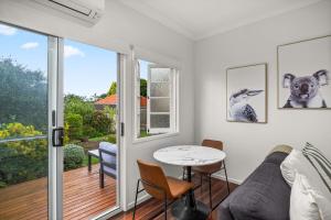 ein Wohnzimmer mit Sofa und Tisch in der Unterkunft Charming 1 Bed Cottage with Garden Retreat in Bald Hills