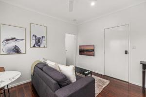 ein Wohnzimmer mit Sofa und Tisch in der Unterkunft Charming 1 Bed Cottage with Garden Retreat in Bald Hills