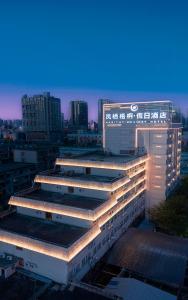 a view of a building in a city at night at Fengqi Wutong Holiday Hotel - Changsha Wuyi Avenue Railway Station Metro Station Branch in Changsha