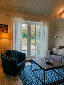 a living room with a couch and a chair and a table at Magical Barn Near The Sea in Ytterby +31 photos