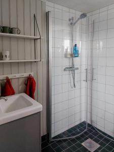 a white bathroom with a shower and a sink at Magical Barn Near The Sea in Ytterby