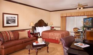 a hotel room with a bed and a couch at Folk Inn Ontario Airport in Ontario
