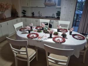 a dining room table with red and white plates and chairs at Luxury central in Craiova +2 photos
