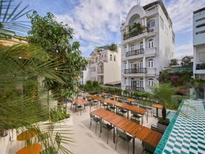 an outdoor patio with tables and chairs and a building at Cozy Room Featuring Local Rattan & Bamboo in Ho Chi Minh City