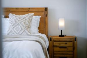 a bed with white sheets and a lamp on a night stand at Seednest BBQ Cozy Family house in Alfredton +20 photos