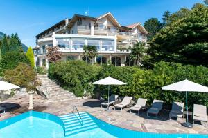 uma grande casa com piscina, cadeiras e guarda-sóis em Hotel Sonnbichl em Tirolo