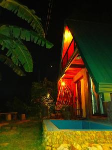 a house with a light on the side of it at night at Ella Shia Cabana in Badulla