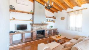 ein Wohnzimmer mit Kamin und Fernseher in der Unterkunft Casa Balcon de la Axarquia Almachar by Ruralidays in Almáchar