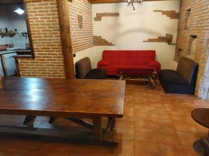 a room with a table and a red couch at Complejo rural la Badia in Lucillos