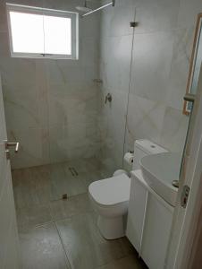 a white bathroom with a toilet and a shower at See n Bos in Gqeberha