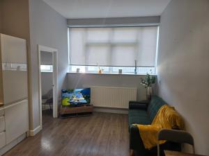 a living room with a couch and a tv at Chris cosy retreat in Buckinghamshire