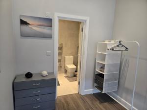 a bathroom with a blue dresser and a toilet at Chris cosy retreat in Buckinghamshire