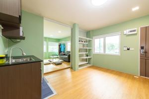 an empty kitchen and living room with green walls at GL Sport Club Serviced Residence & Hotel in Bangkok