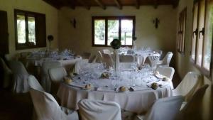 a room with white tables and chairs with white tablecloths at Complejo rural la Badia in Lucillos