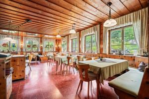 a dining room with tables and chairs and windows at Landgasthof Rössle in Kressbronn am Bodensee