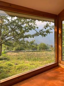 ein Fenster in einem Zimmer mit Blick auf ein Feld in der Unterkunft The Goat Village in Bhatwāri