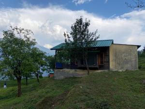 ein kleines Haus auf einem Hügel in der Unterkunft The Goat Village in Bhatwāri