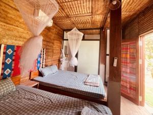 a bedroom with two beds and a wooden ceiling at Mai Châu Medifarm Retreat in Mai Chau +111 photos